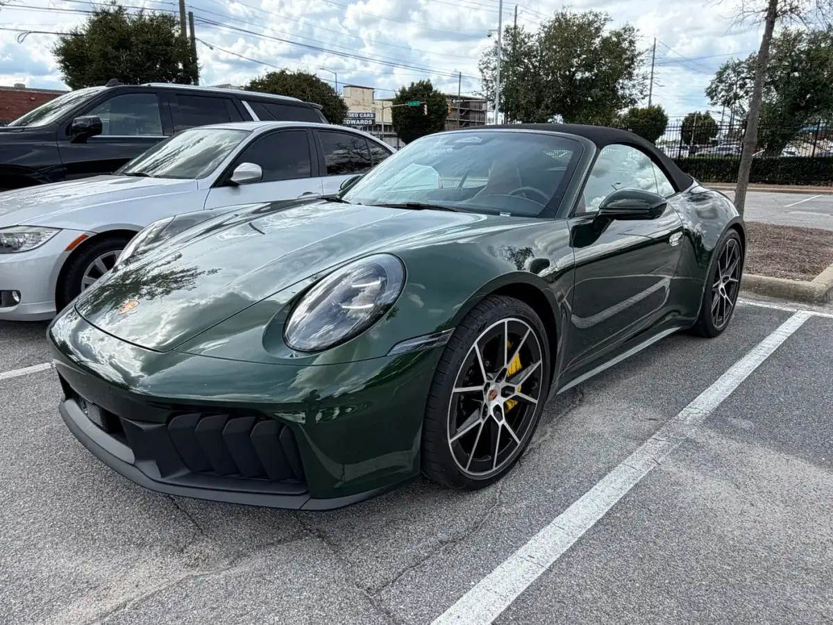 Full-vehicle photo of the green Porsche 911 on the dealer lot